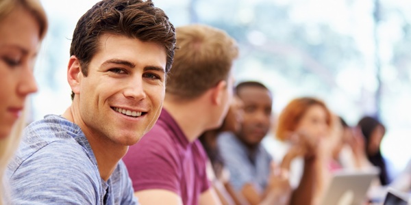 Male Student With Others Using Tablet